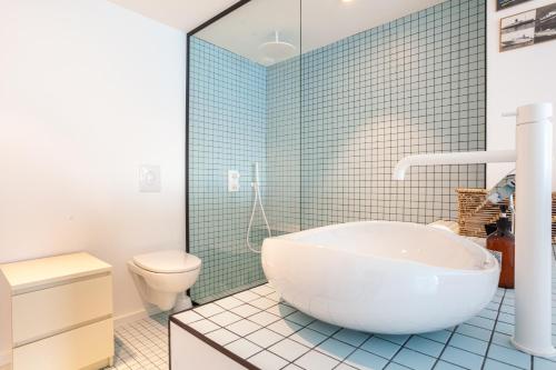 a bathroom with a white tub and a toilet at CASA UMI - Magnifique appartement avec accès privé à la mer et grande terrasse in Marseille