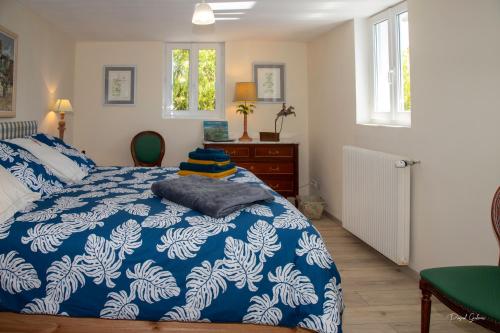 - une chambre avec une couette bleue et blanche sur un lit dans l'établissement villa marguerite 65 rue legout lesage 76260 ponts et marais, à Mers-les-Bains