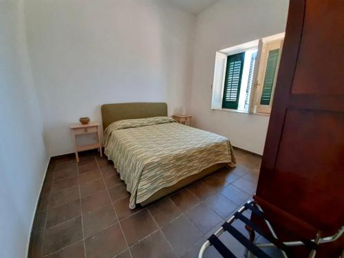 Habitación pequeña con cama y ventana en RELAIS COUNTRY HOUSE - TERRACE on AEOLIAN ISLANDS, en Acquedolci