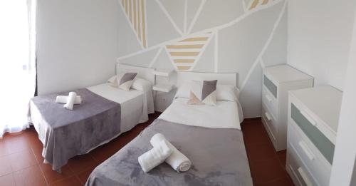 a white room with two beds and a staircase at Casa Abian in Arrecife