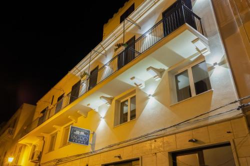 a yellow building with a clock on the side of it at Isgrò Rooms in Marsala