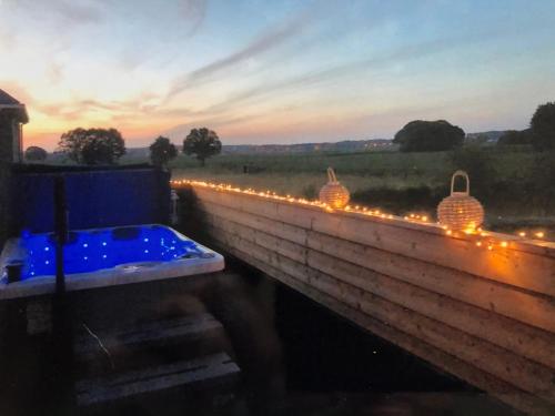 a hot tub with lights on a brick wall at Welness gastenverblijf Carpe Diem in Oudsbergen 