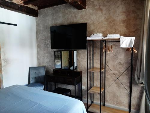 um quarto com uma cama e uma televisão na parede em Toscana Made in Love em Massa