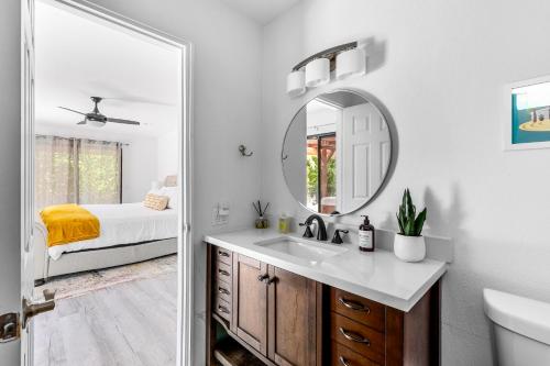 a bathroom with a sink and a mirror at Poolside Palm Springs Paradise in Palm Springs