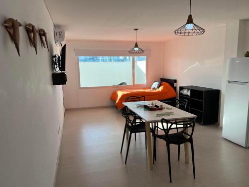 a room with a table and chairs and a refrigerator at APART trelew 5 in Trelew