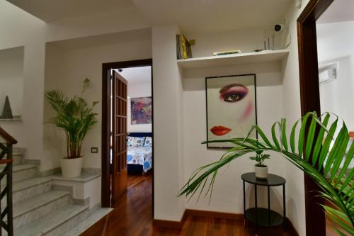 um corredor com uma pintura de uma mulher com batom vermelho em Amaranda B&B em Catânia