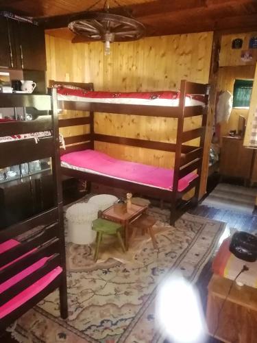 a room with two bunk beds and a table at Mala Kelja in Rudnik Kačerski
