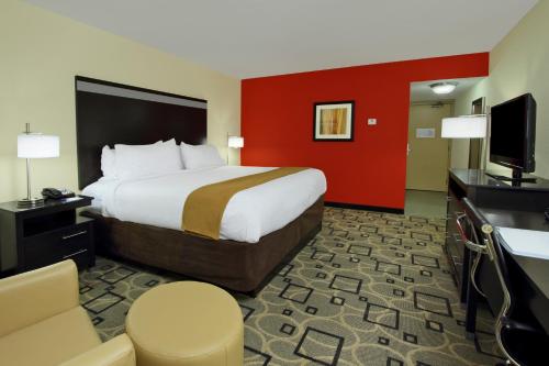 a hotel room with a bed and a flat screen tv at Holiday Inn Express Augusta Downtown by IHG in Augusta