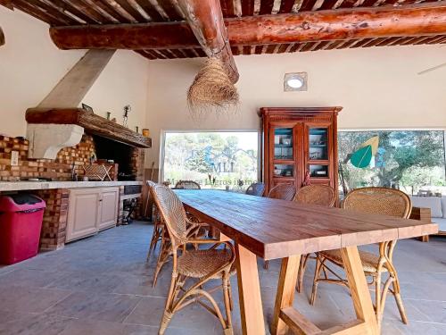 ein großes Esszimmer mit einem Holztisch und Stühlen in der Unterkunft Mas Le Cad Saint-Rémy de Provence 8 personnes in Saint-Rémy-de-Provence