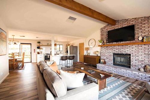 a living room with a couch and a brick fireplace at Cozy Rustic Home minutes to Joshua Tree Nat'l Park in Joshua Tree