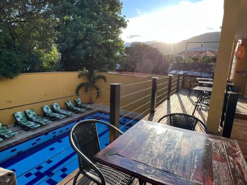 un patio con mesa, sillas y piscina en Curazao Hotel -Centro Histórico- en Santa Fe de Antioquia