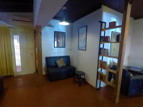 a living room with a blue couch and a book shelf at Cataratas Jazz Hostel in Puerto Iguazú