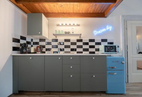 a kitchen with black and white tiles on the wall at MOOKI Rumbach Budapest Apartment in Budapest