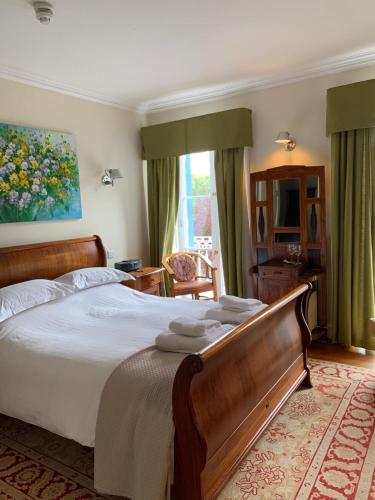 una camera da letto con un grande letto con asciugamani di Borthwnog Hall a Dolgellau
