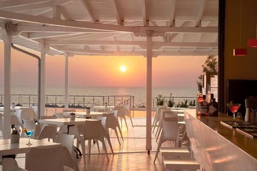 a restaurant with a view of the ocean at sunset at Adorable 2 floors two bedroom vacation maisonette in Nea Potidaea