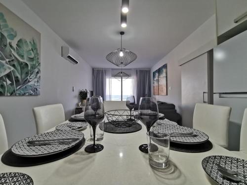 a dining room with a table with plates and wine glasses at COSea Living: Seaside Two Bedroom Flat in Harbour 106 in Paphos City