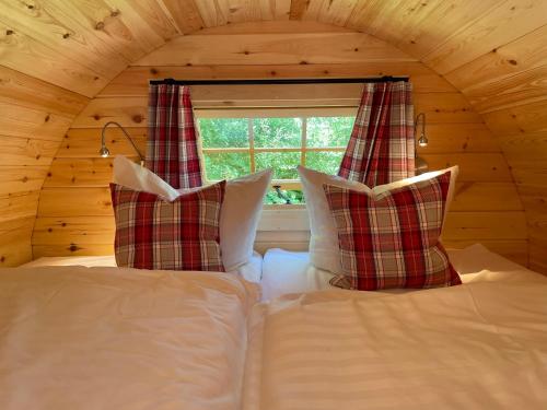 a bed with two pillows and a window in a room at Timmi Lake in Timmendorfer Strand