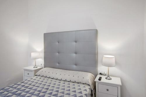 a white bedroom with a bed and two night stands at Casa Micaela 1 in Tacoronte