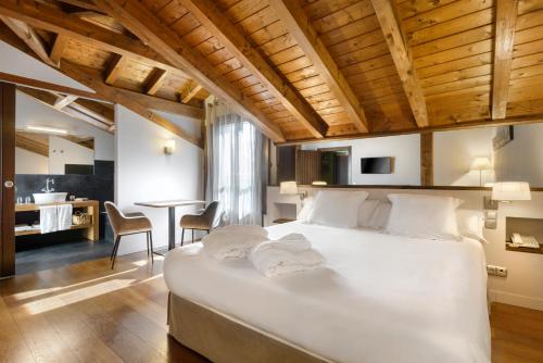 a bedroom with a large white bed and a table at Hotel Rural Iribarnia in Lantz