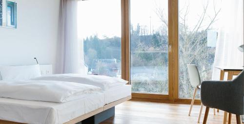 a bedroom with a bed and a large window at OX Hotel Altes Spital in Müllheim