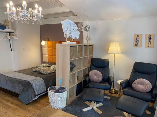 a bedroom with a bed and two chairs at Vakantiehuisje De Waterhoek in Geel