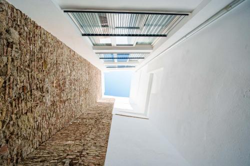 an empty hallway with a brick wall and skylight at Homely Málaga Mariblanca 17, Vegafuente Apartments in Málaga
