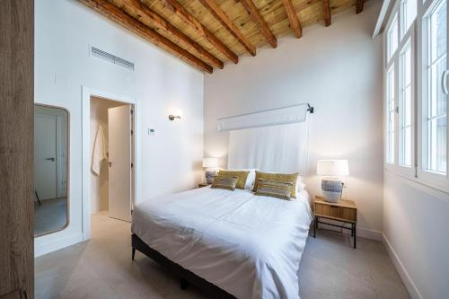 a bedroom with a large bed and a window at Homely Málaga Mariblanca 17, Vegafuente Apartments in Málaga