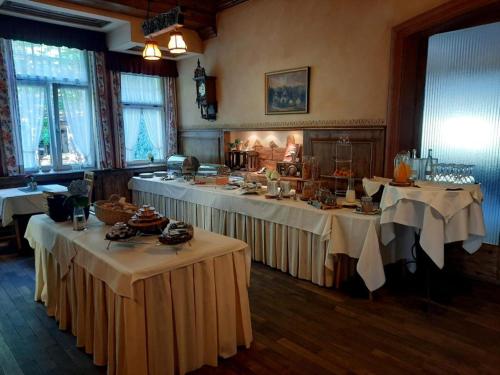 een kamer met twee tafels met witte tafelkleden bij Hotel Dammenmühle in Lahr