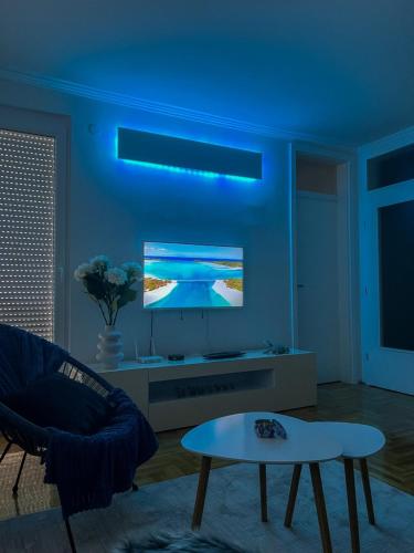 a living room with a blue ceiling and a tv at Apartman ML in Lukavica