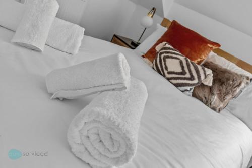 a white bed with towels on top of it at 2 Bed- The Penthouse By Pureserviced in Plymouth