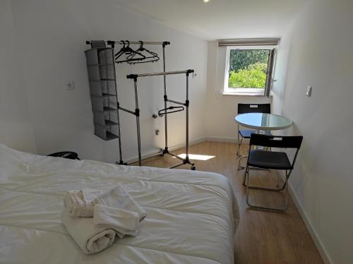 a bedroom with a bed and a table and a window at Casa Penedo do Raposo in Muxagata