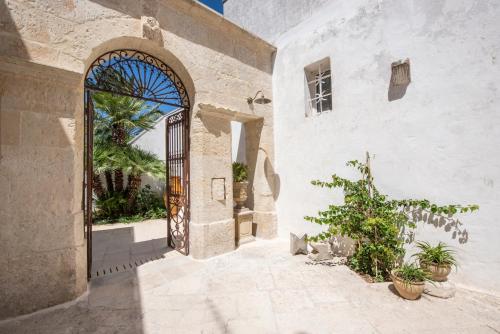 Palazzo Angelica BeB Salento - bed and breakfast Otranto في جوردينيانو: مدخل لمبنى مع بوابة