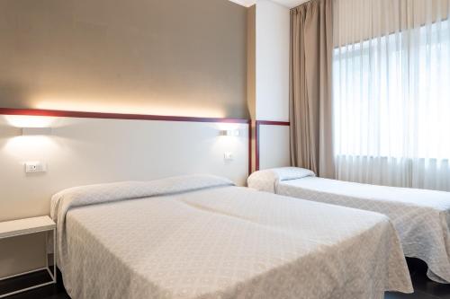 a hotel room with two beds and a window at Hotel Centrale in Mestre