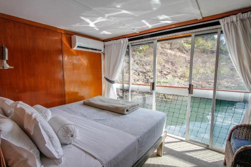 a bedroom with a bed in front of a window at Shayamanzi Houseboats in Jozini
