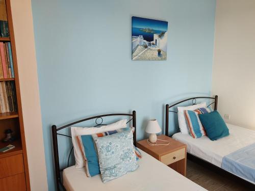 a bedroom with two beds and a book shelf at Villa Lena in Kastraki Naxou