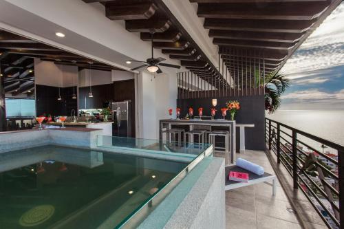 an indoor swimming pool in a house with a kitchen at Pinnacle Resorts 180 in Puerto Vallarta