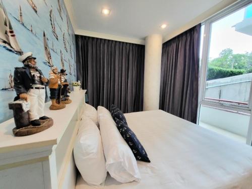 a room with a bed with pillows and a window at My resort by Sea room in Hua Hin