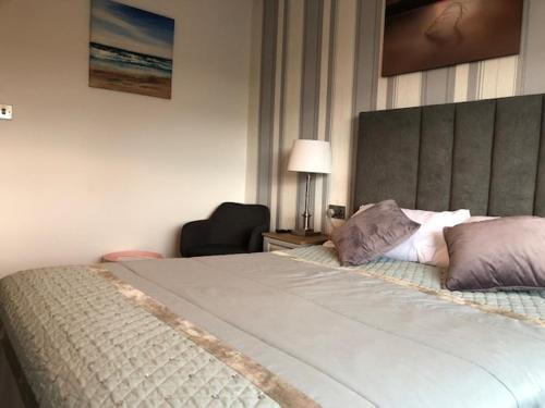 a bedroom with a large bed and a chair at Seacrest in Galway