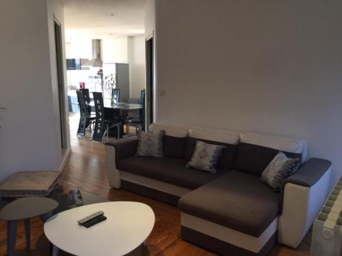a living room with a couch and a table at MONTALIEU SEJOUR Appartement les orchidées, 4 pers in Montalieu-Vercieu