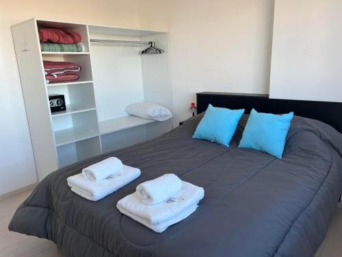 um quarto com uma cama grande e toalhas em APART trelew 5 em Trelew