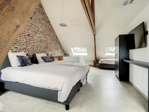 a bedroom with a bed and a brick wall at Riversight in Les Deux-Acren