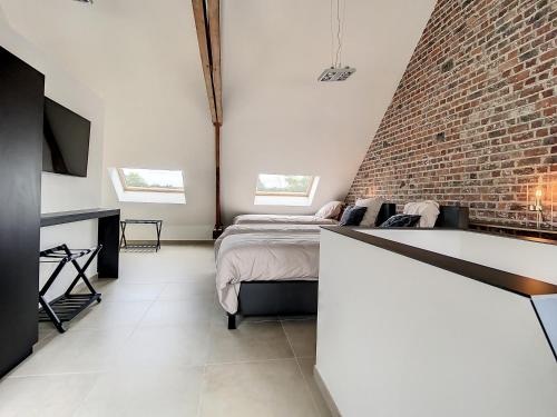 a bedroom with a bed and a brick wall at Riversight in Les Deux-Acren