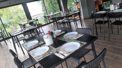 a restaurant with tables and chairs in a room at Zöldház Panzió in Gyenesdiás
