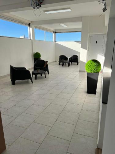 a lobby with chairs and plants in a building at APART trelew 5 in Trelew