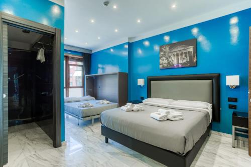 una camera con due letti e una parete blu di AR ROOMS ROME a Roma