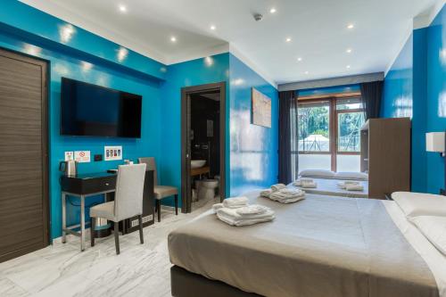 una camera da letto con pareti blu, un letto e una scrivania di AR ROOMS ROME a Roma