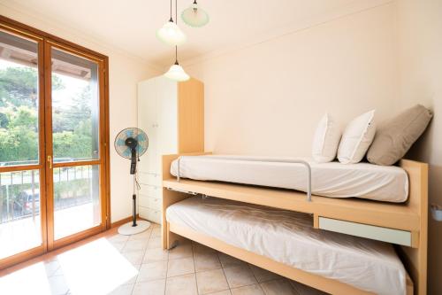 a bedroom with a bed and a window at Appartamento Katy in Polpenazze del Garda