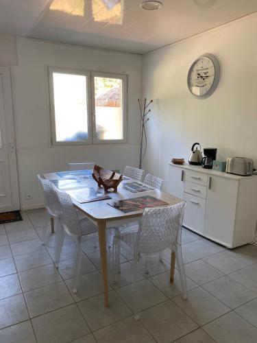 eine Küche mit einem Holztisch, Stühlen und einer Theke in der Unterkunft Suite Saona in Feuquières