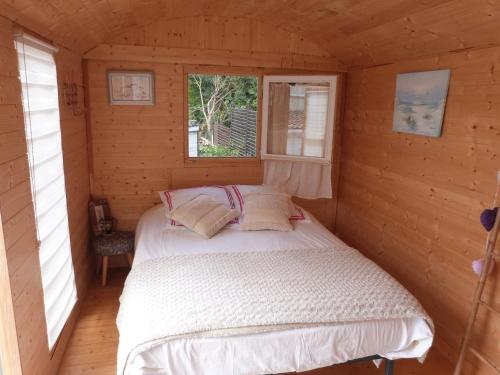 ein Schlafzimmer mit einem Bett in einer Holzhütte in der Unterkunft CHEZ CLAUDINE ET PASCAL in Châlons-en-Champagne