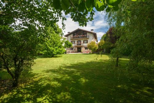 een groot huis midden in een groene tuin bij Hotel Rural Iribarnia in Lantz